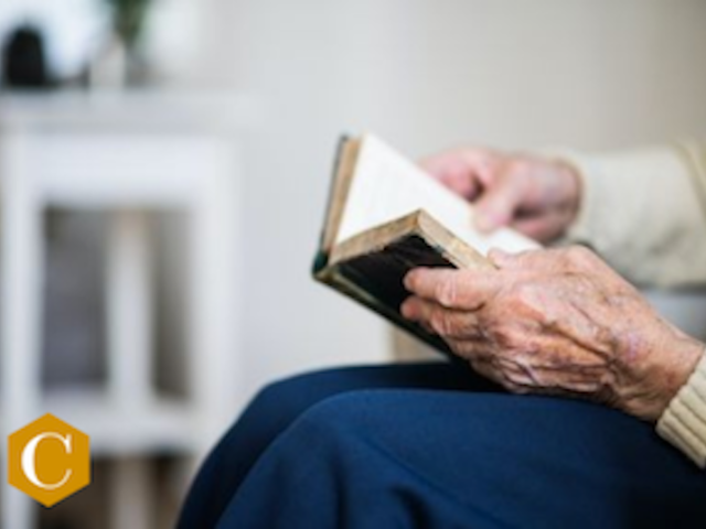 elderly hands holding a book
