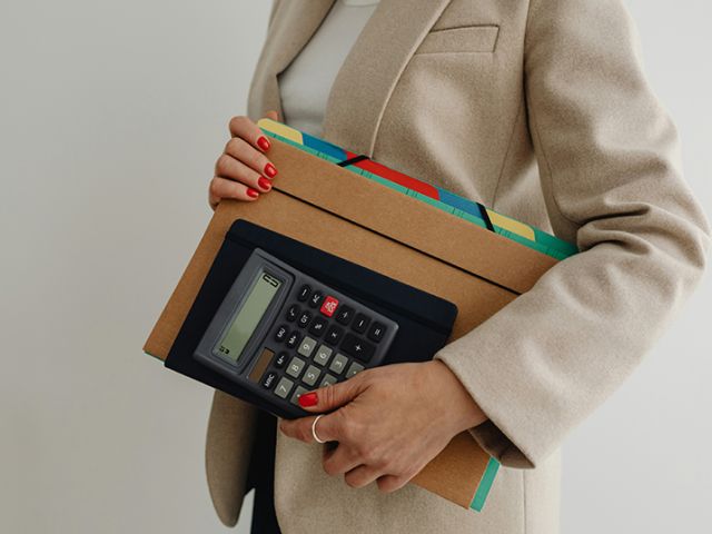 Women holding folders and calculator